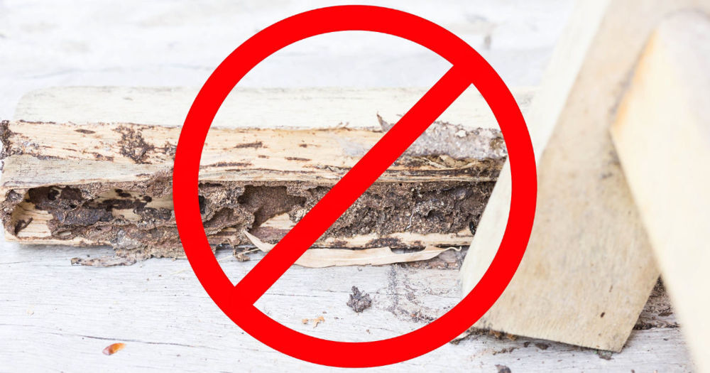 The image shows a piece of severely damaged wood with signs of rot and decay, highlighting the crumbling and disintegrated interior structure. Over the image, there is a large red prohibition symbol, consisting of a circle with a diagonal line through it, indicating a strong warning or restriction against wood rot.